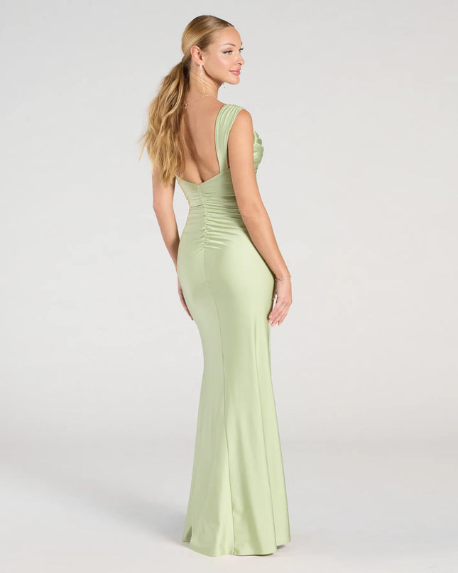 The Kaitlin Low Back Slit Mermaid Formal Dress in sage is a stunning green prom dress designed to capture attention with its fresh or bold color and effortlessly stylish silhouette.